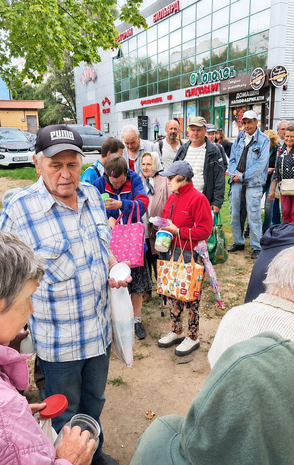 Люди в черзі за безкоштовними гарячими обідами в Харкові
